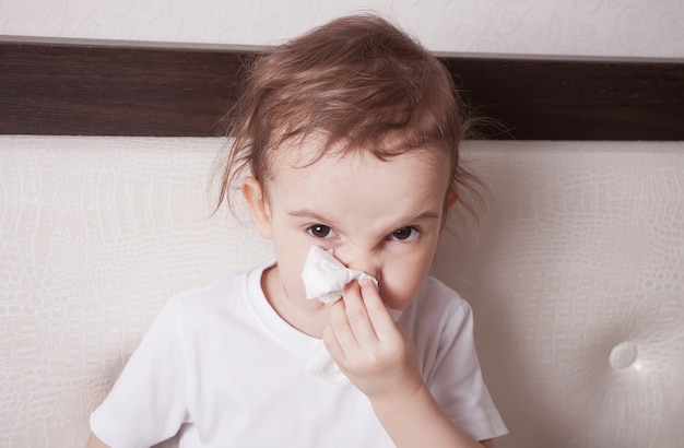 Photo sick cute little girl blowing her nose