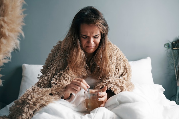 Photo a sick girl with a disgusted face is drinking her medicine