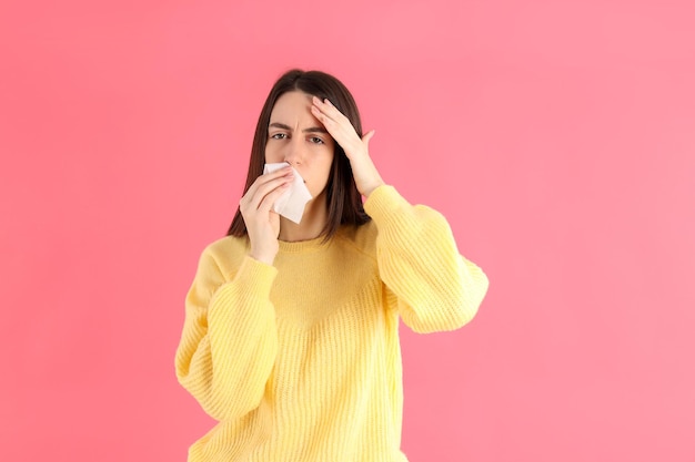 Sick girl in a yellow sweater on a pink background