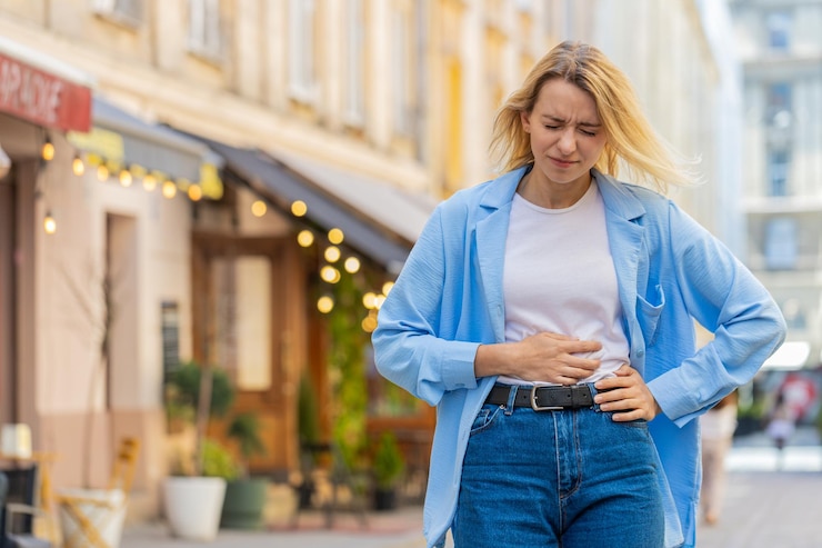 Photo sick ill woman suffering from period cramps stomach ache menstrual pain gastritis on city street