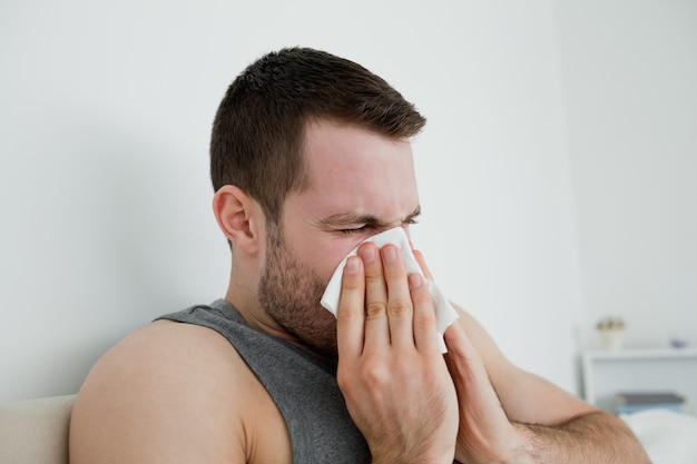 Sick man blowing his nose