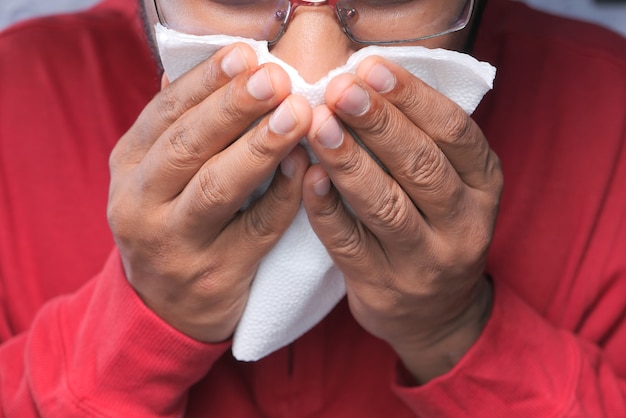 病気の人はインフルエンザのアレルギーがくしゃみをして鼻をかむ