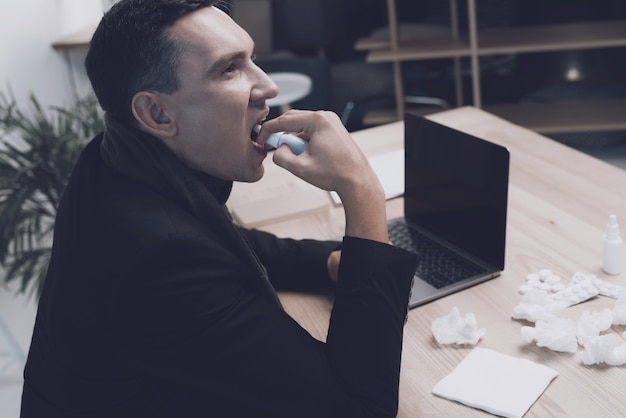 Photo a sick man is sitting at his workplace in the office.