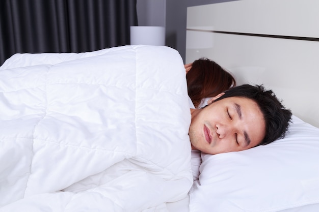 больной человек спит на кровати с женой