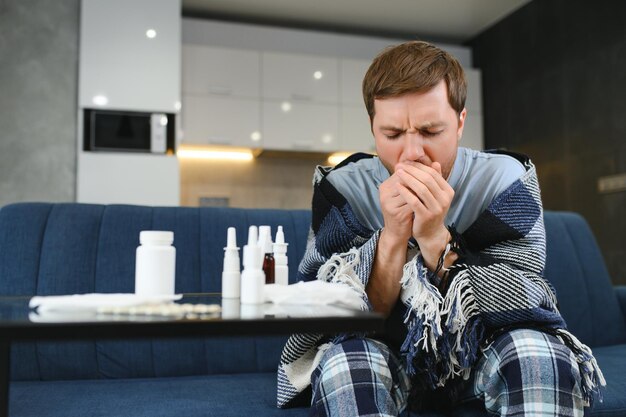 Sick man on sofa at home in living room