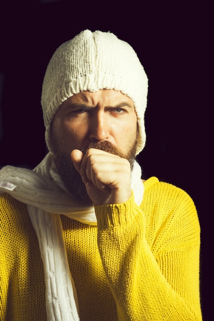 Sick man in sweater hat and scarf while having cough has cold and flu winter style clothes concept