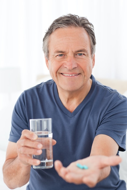 病気の男は彼の薬を飲んで