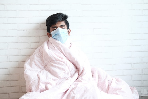 sick man with blanket sitting on bed