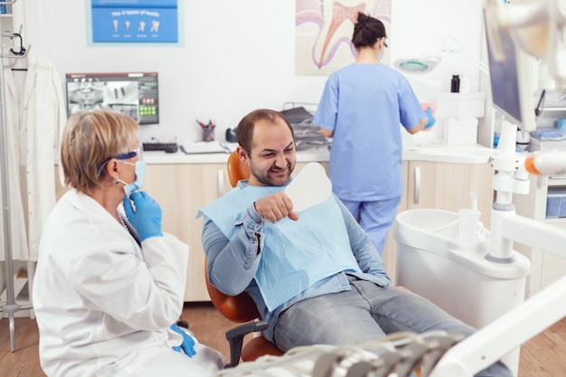 Sick patient checking health teeth analyzing surgery procedure in mirror