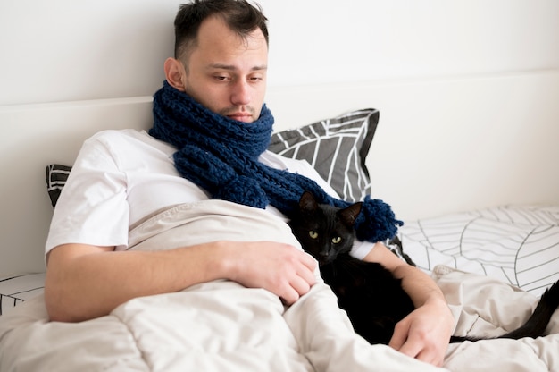 写真 黒い子猫を保持している病気の人