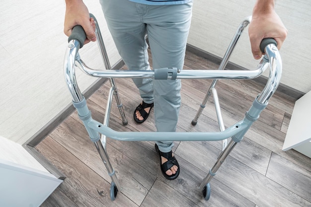 Photo sick person walks with the help of special devices for rehabilitation walkers for adults rehabilitation after a broken leg or stroke