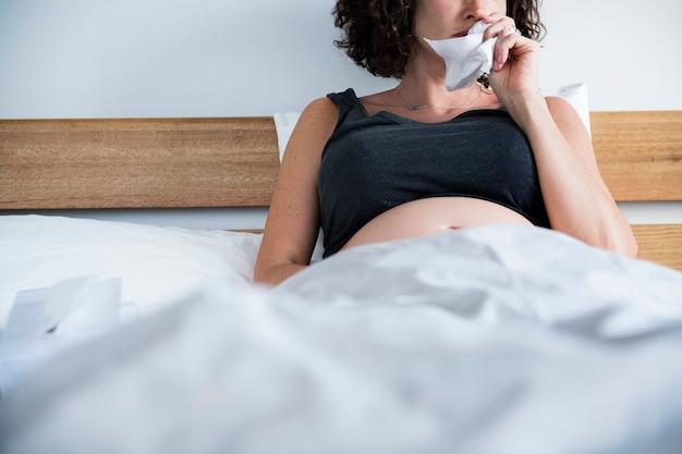 ベッドの上の病気の妊娠中の女性