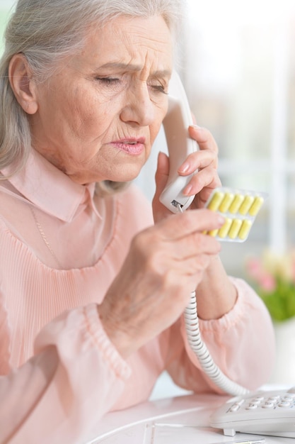 Sick senior woman sitting at table