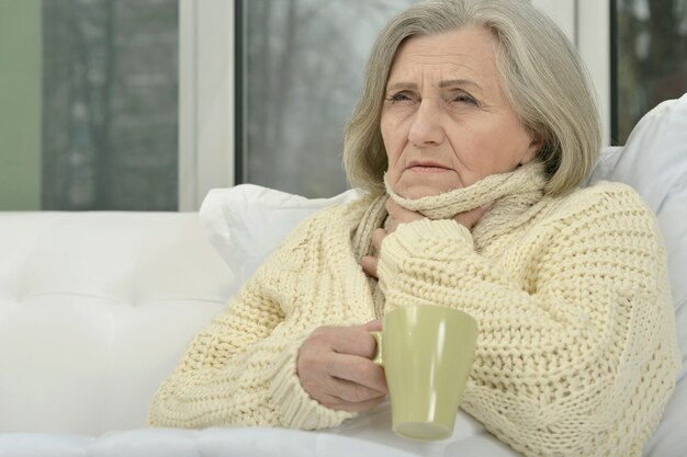 Sick senior woman  with cup of tea at home