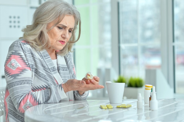 Sick senior woman with pills