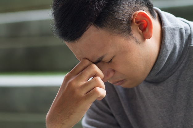 Uomo malato del sud-est asiatico con mal di testa, depressione, stress