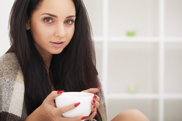 Sick woman in bed,calling in sick,day off from work.Drinking herbal tea.Vitamins and hot tea for flu.