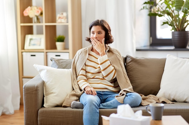 Photo sick woman in blanket coughing at home