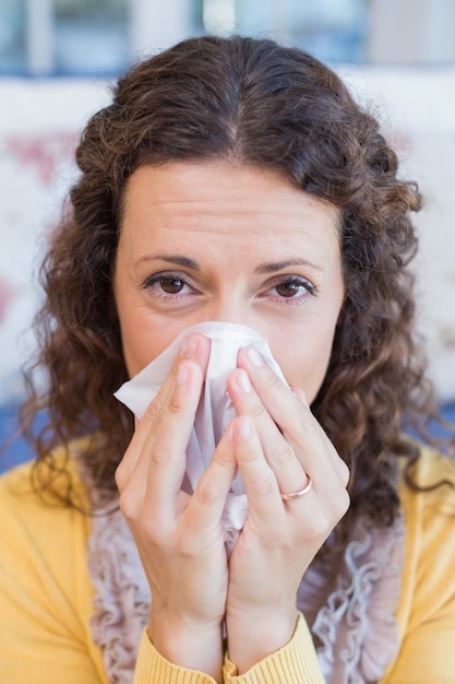 Sick woman blowing her nose