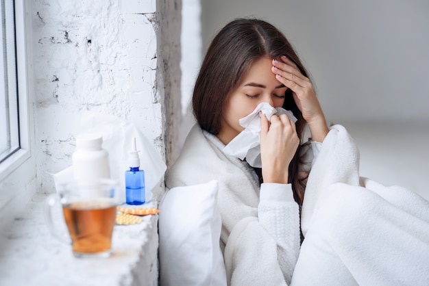 Sick woman caught cold, feeling illness and sneezing in paper wipe