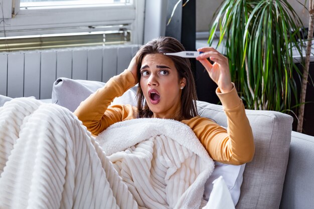 Sick woman checking her temperature