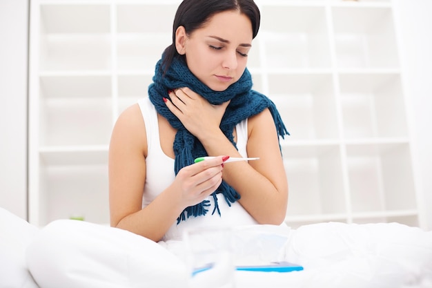 Donna malata. influenza. ragazza con il freddo che si trova sotto una coperta che tiene un fazzoletto