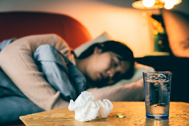 Sick woman have a cold and sleeping on sofa ,selective and soft focus.