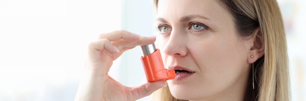 Sick woman holding hormone inhaler near mouth treatment of bronchial asthma concept