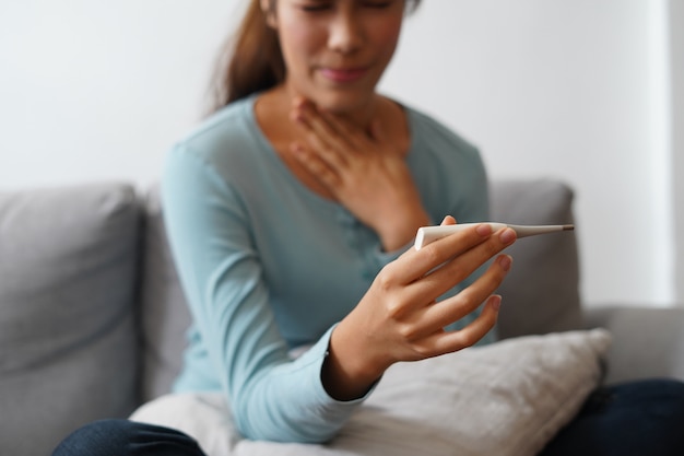 Sick woman measuring temperature her body and got fever