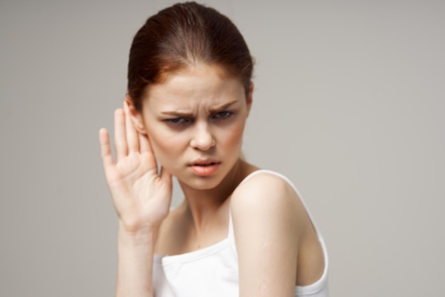 Sick woman poor hearing disorders in white tshirts studio treatment