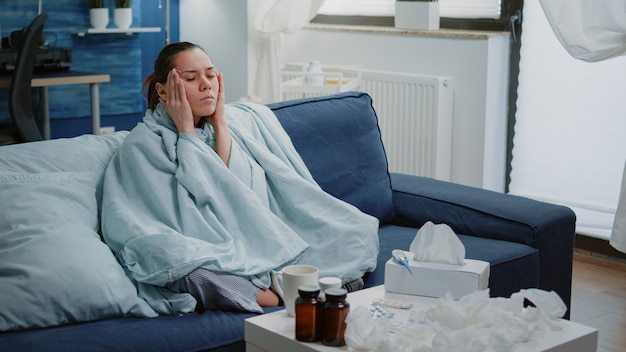 Sick woman rubbing temples and trying to cure headache