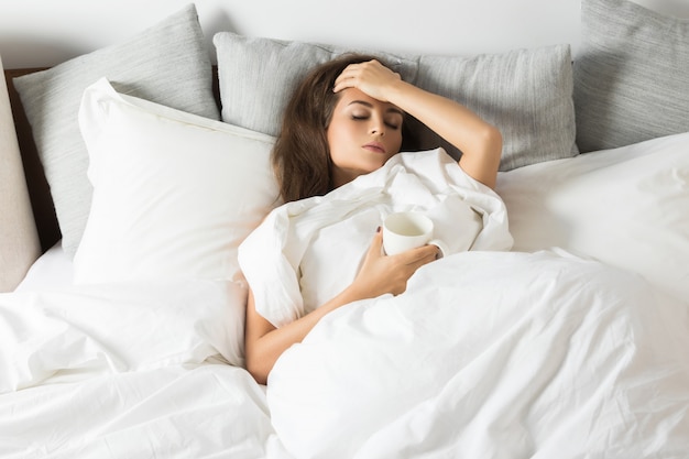 Sick woman sitting under a blanket