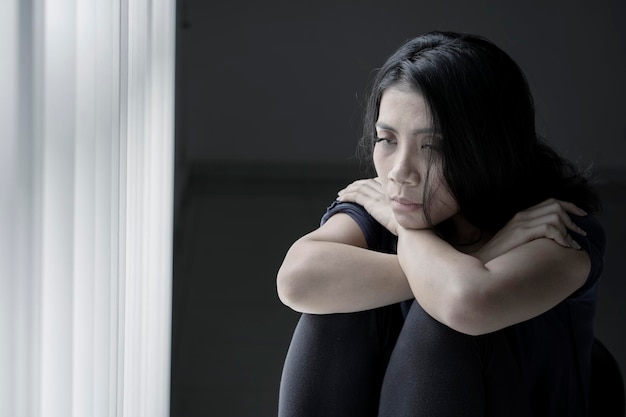 Sick woman sitting near the window