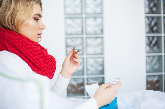 Photo sick woman suffers from a cold at home