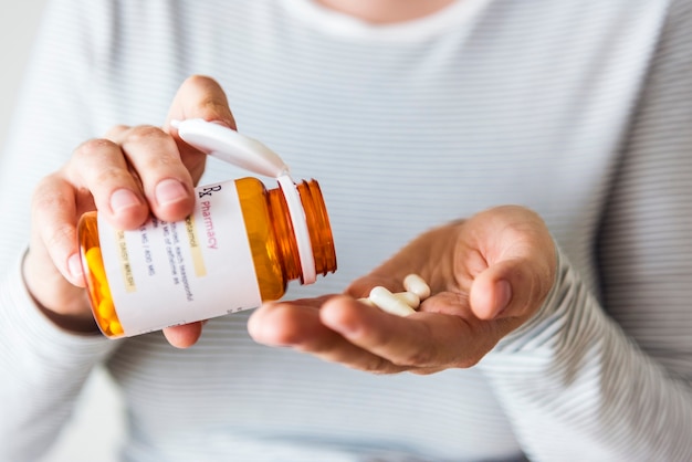 Sick woman taking pills from bottle