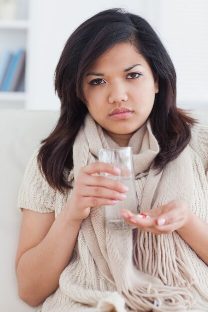 病気の女性が薬を飲む