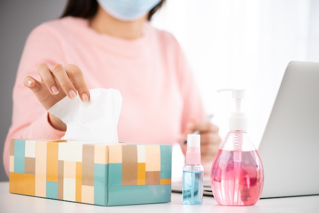 Sick woman taking white tissue paper while cough for prevention Coronavirus (COVID-19).