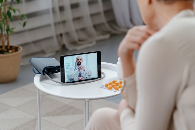 Sick woman using a digital tablet for medical advice .