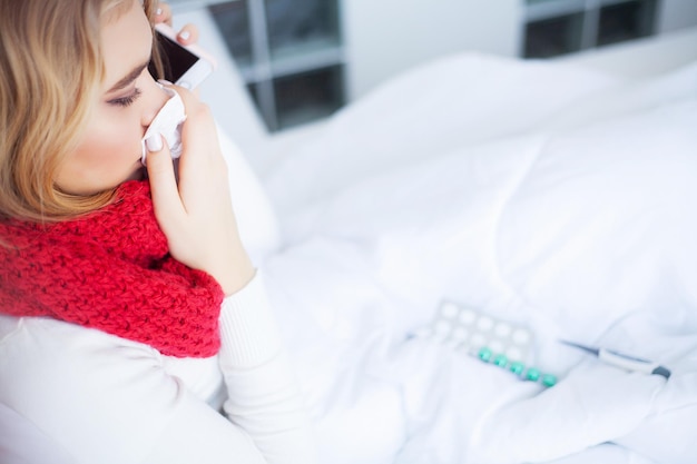 Больная простуженная женщина лечится дома в постели