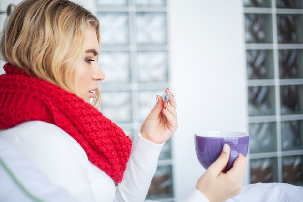 Sick woman with flu. Woman Suffering From Cold Lying In Bed With Tissue.