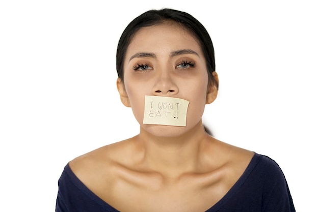 Sick woman with her mouth covered by a paper