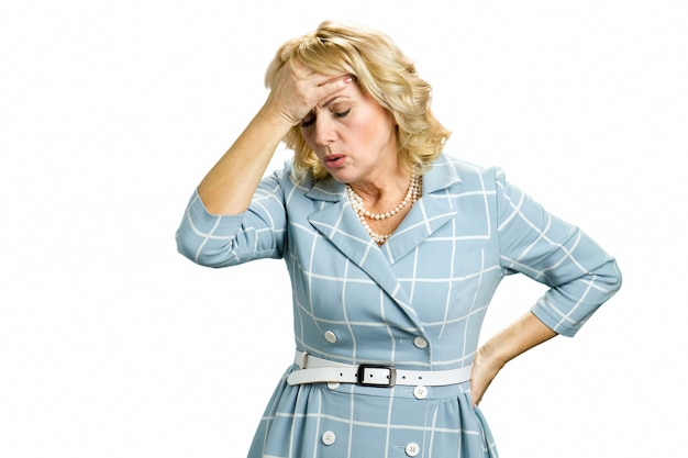 Sick woman with stong headache. Mature woman having headache touching her forehead on white close up.