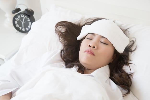 Sick young asian woman lying on bed