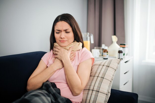 Sick young woman sit on couch