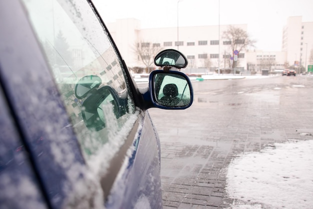 Боковое зеркало автомобиля в снегу
