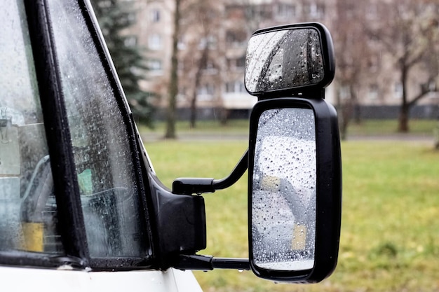 Side mirror of a car with raindrops