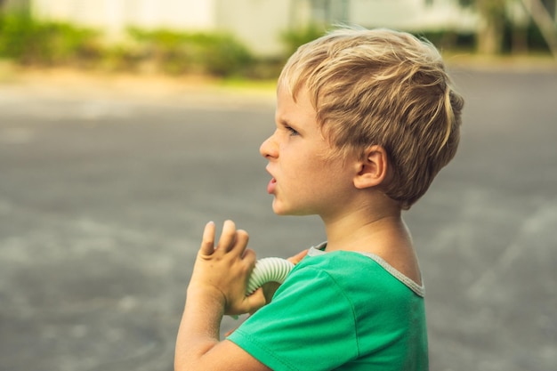 Side portrait blond serious boy with freckles frowns wrinkles nose artistic emotions facial expression gesturing Family relationship micro moments of childhood compassion toward humanity society