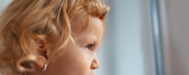 Side portrait of child girl face looking away. Closeup view. Panoramic photo with copy space.