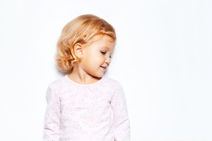 Side portrait of child girl with curly blonde hair.