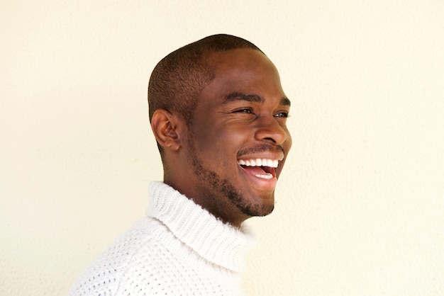 Side portrait of handsome african american man in sweater laughing and looking away